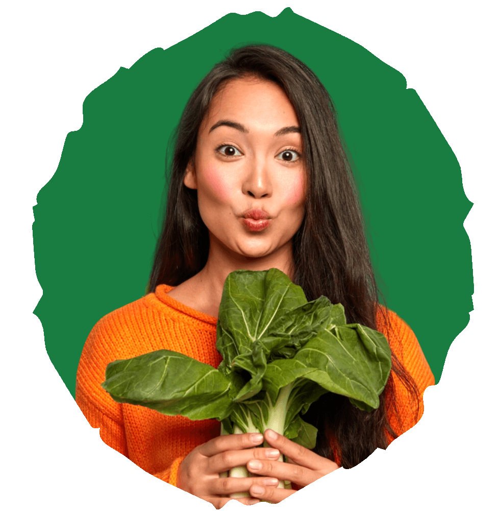 lady blowing a kiss while holding a vegetable on a green background