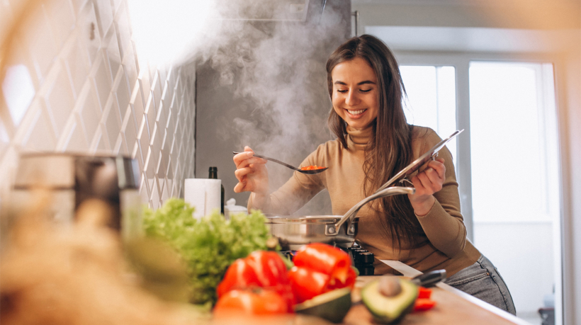 woman cooking with vegetables in kitchen