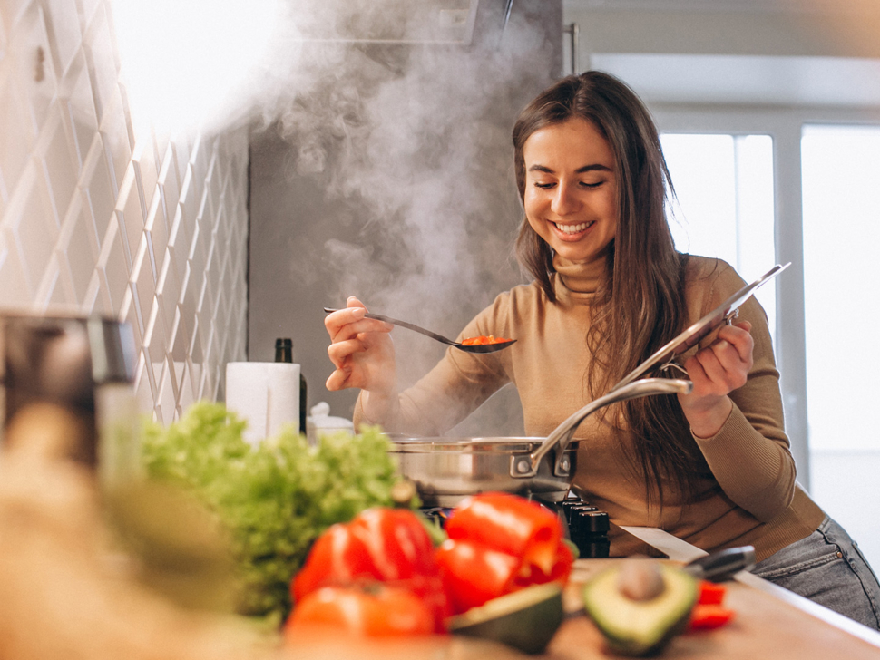 woman cooking with vegetables in kitchen